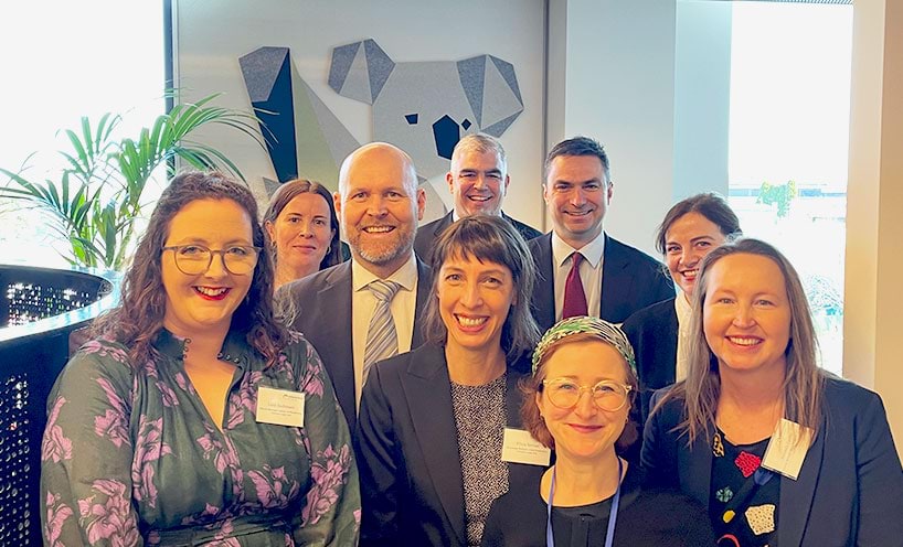 Victoria Legal Aid staff with Judge Vandersteen, President Children’s Court at the opening of the Dandenong Children's Court. The group are standing in front of a koala wall mural.