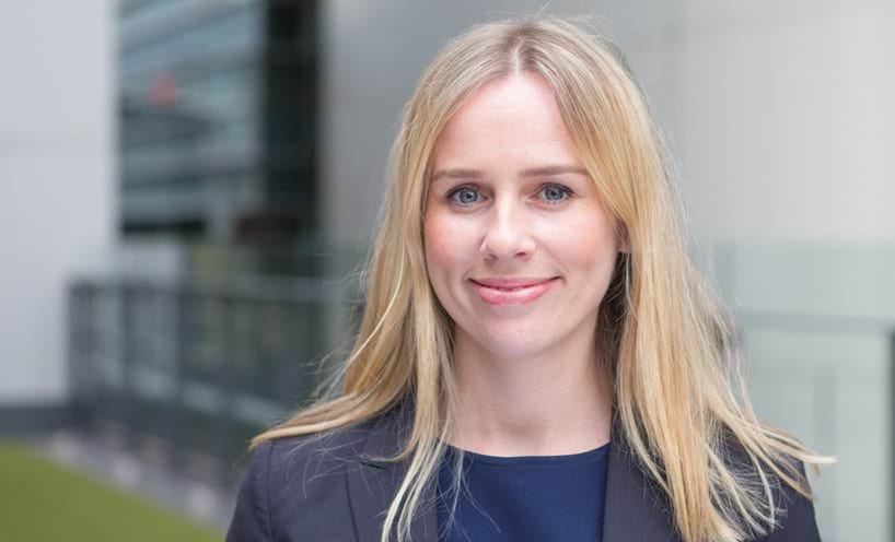 A head shot of Tamsin. She has long blonde hair, blue eyes and is wearing a navy coloured suit.
