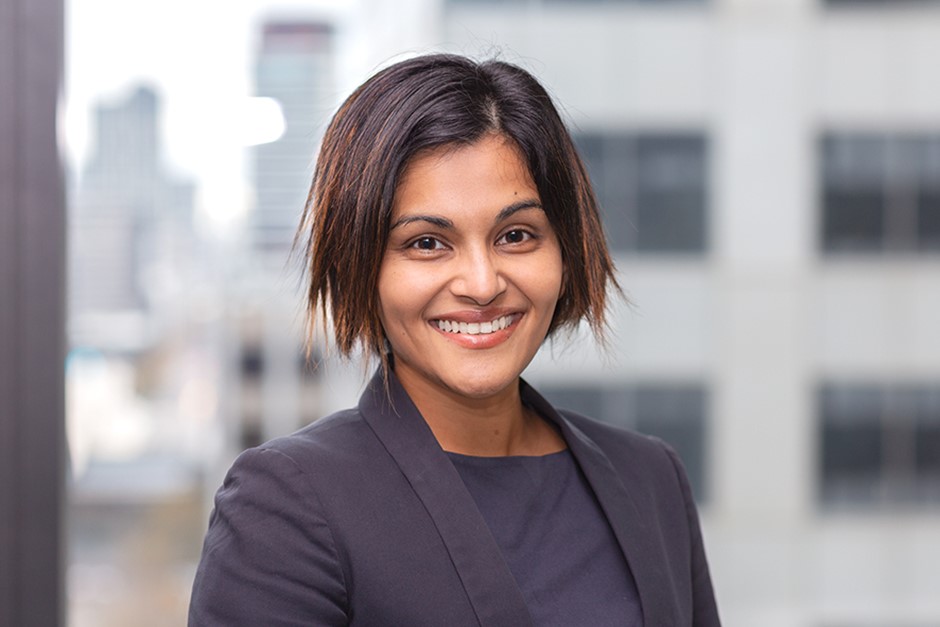 Iresha Siriwardana headshot. Iresha is wearing a grey suit and grey shirt.