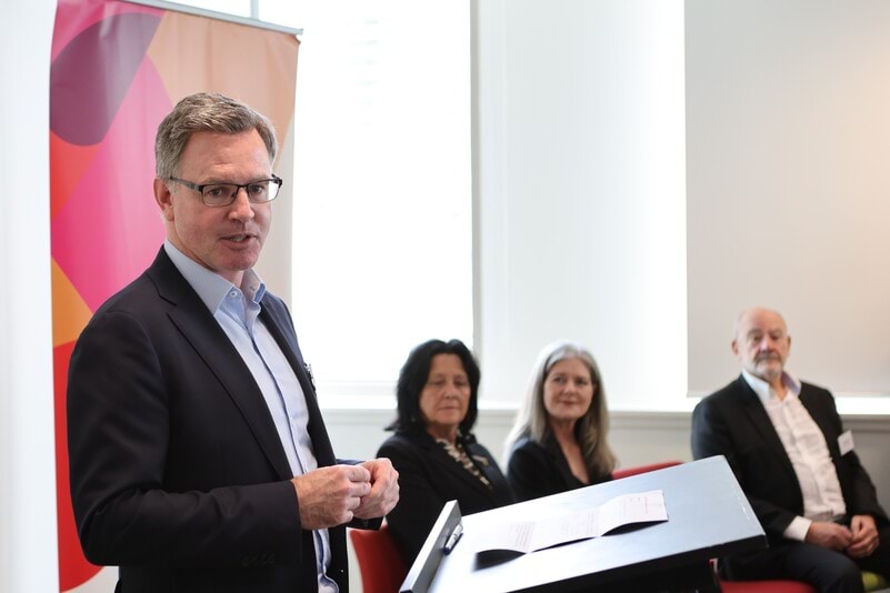 Toby Hemming speaking at lectern at Geelong office reopening event.